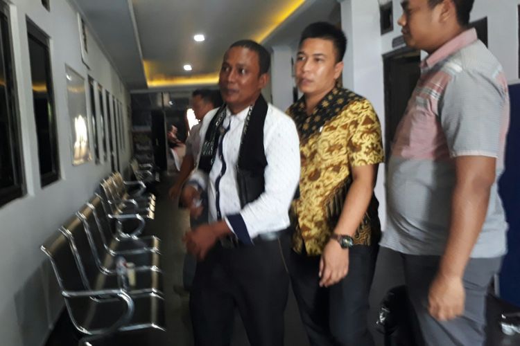Kakak tersangka pembunuh pegawai BNN, MT (baju putih) saat mendatangi Polres Bogor untuk menjalani pemeriksaan, Jumat (8/9/2017).