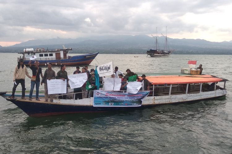 Pegiat lingkungan saat membentangkan sepanduk dan poster di perairan Teluk Bima, Rabu (11/5/2022).