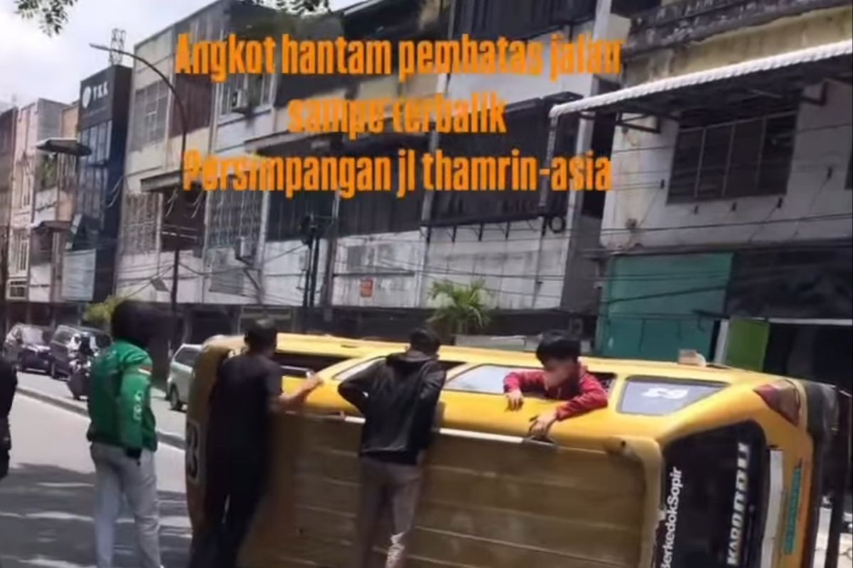 Satu unit angkutan kota terbalik karena menabrak pembatas jalan di Jalan Thamrin, Kota Medan pada Jumat (7/3/2025). Video kecelakaan itu pun viral karena penumpang berusaha keluar dari jendela angkot.