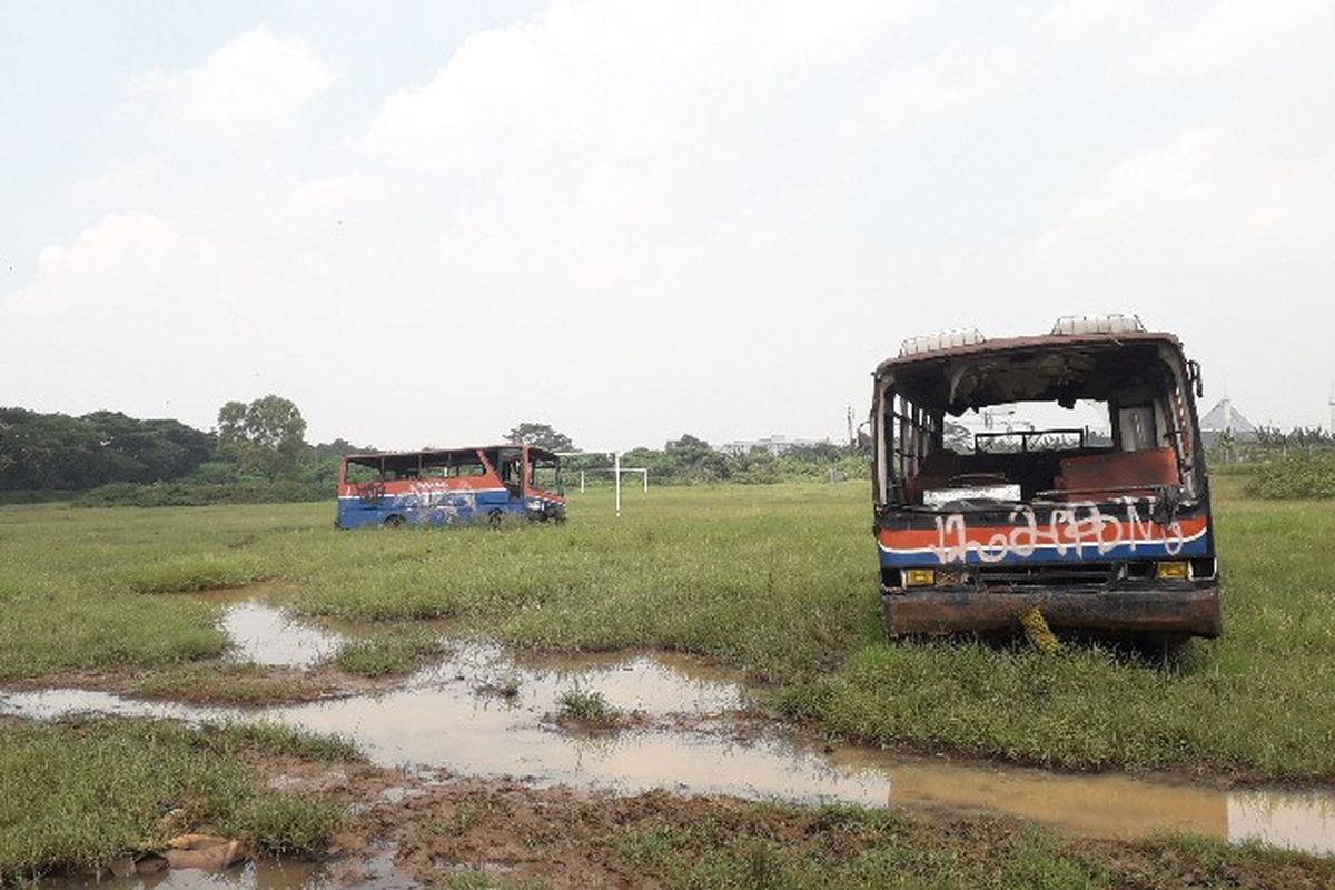 Bus tua yang ada di Terminal Mobil Rawa Buaya, Jakarta Barat berbagi lahan lapangan dengan kerbau liar pada Jumat (16/3/2018).