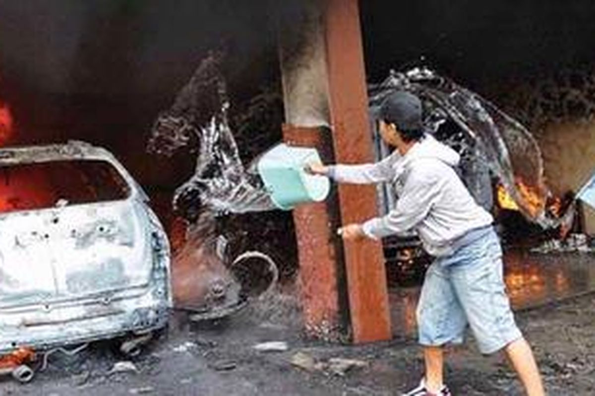 Petugas gereja berupaya memadamkan api yang menghanguskan mobil-mobil yang terdapat di areal parkir Gereja Pantekosta di Indonesia di Temanggung, Jawa Tengah, Selasa (8/2/2011).