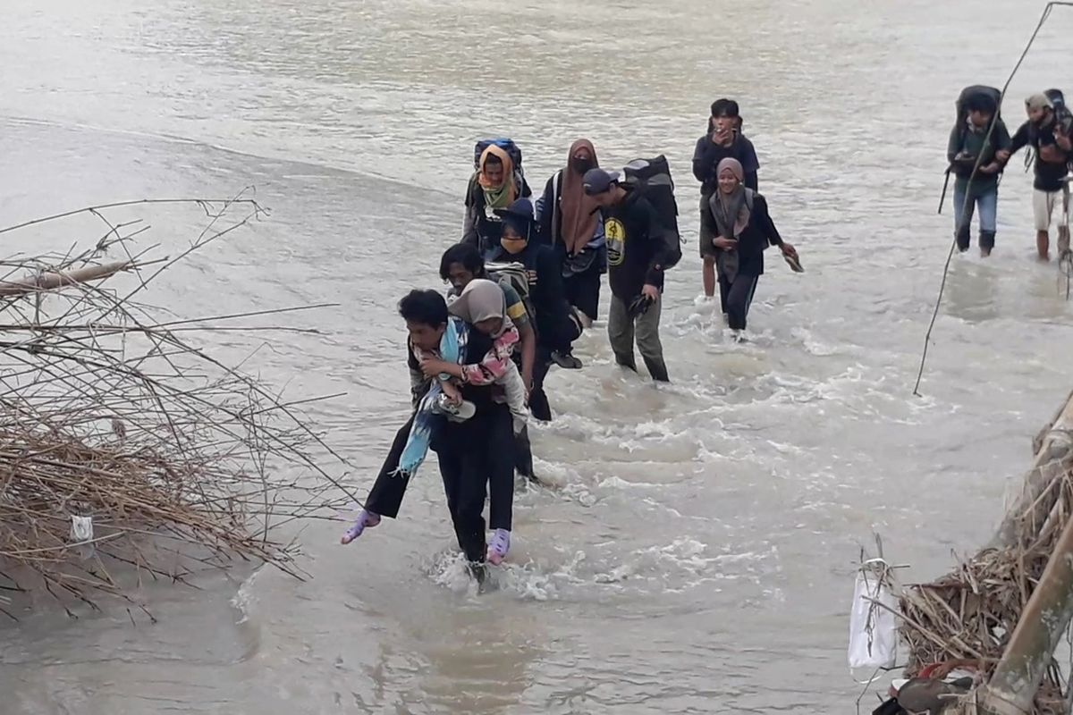 Relawan Muhammadiyah Disaster Managemen Centre (MDMC) menyeberangi sungai untuk mengantar logistik di pengungsian warga Desa Maipi, Kecamatan Masamba, luwu Utara, Senin (27/07/2020)