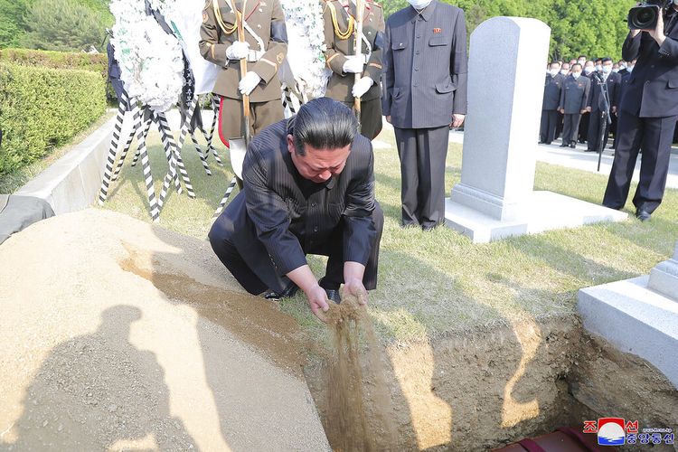 Dalam foto yang disediakan oleh pemerintah Korea Utara ini, pemimpin Korea Utara Kim Jong Un menutupi peti mati Marsekal Tentara Rakyat Korea Hyon Chol Hae dengan tanah di pemakaman di Pyongyang, Korea Utara Minggu, 22 Mei 2022.