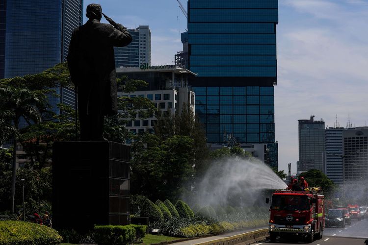 Petugas Pemadam Kebakaran (Damkar) menyemprotkan disinfektan di sepanjang jalan protokol dari monas sampai bunderan senayan di Jakarta, Selasa (31/3/2020). Penyemprotan disinfektan dalam rangka mitigasi pencegahan virus corona (COVID-19).