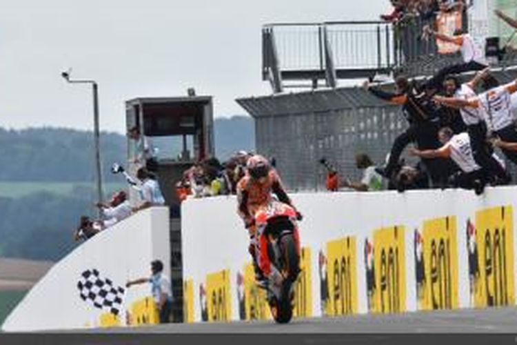 Pebalap Repsol Honda asal Spanyol, Marc Marquez, finis pertama pada GP Jerman di Sachsenring dan disambut timnya, Mingg (13/7/2014).