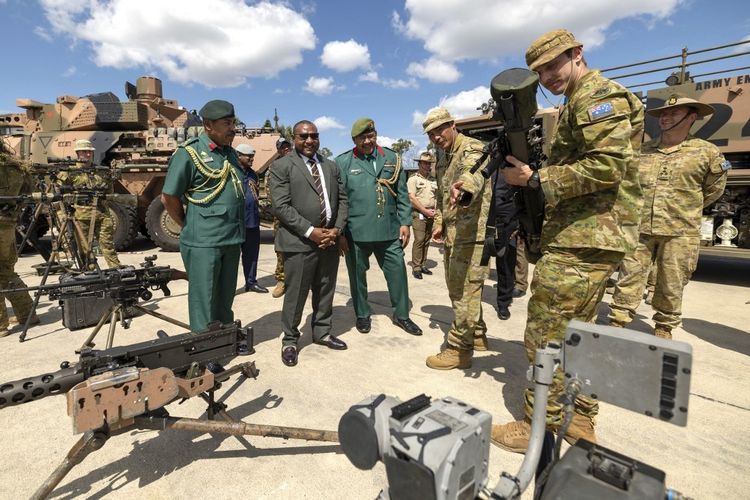 Foto yang diambil pada 20 Februari 2025 dan dirilis oleh Angkatan Pertahanan Australia ini menunjukkan Menteri Pertahanan Papua Nugini Billy Joseph (kedua dari kiri) dan para pejabat berbicara dengan tentara Resimen Kerajaan Australia dari Resimen ke-8/9. Australia dan Papua Nugini akan menandatangani perjanjian pertahanan baru pada Rabu (17/9/2025), berkomitmen saling membela dari ancaman demi menjaga keamanan regional.