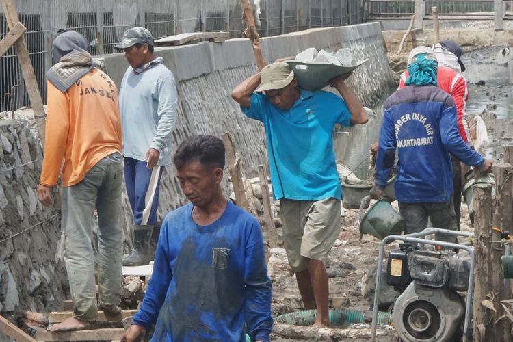 Sejumlah pekerja harian lepas (PHL) Dinas Tata Air DKI Jakarta atau yang biasa dikenal dengan nama Pasukan Biru tengah membangun turap di kawasan Cengkareng, Jakarta Barat, Kamis (6/4/2017). Pasukan Biru bekerja secara berkelompok dan terdiri dari anak muda usia produktif sampai orang dewasa.