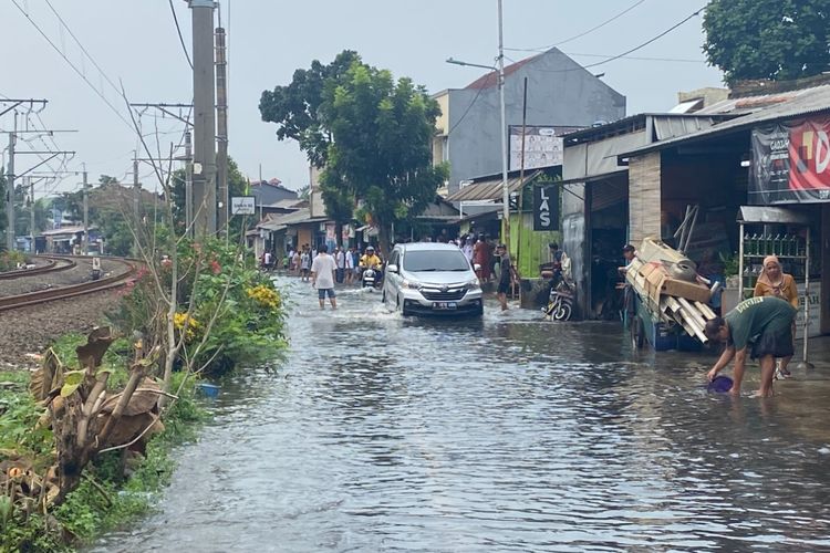 Mobil menerobos banjir di Jalan Bintaro Permai IV pada Selasa (16/9/2025) sore.