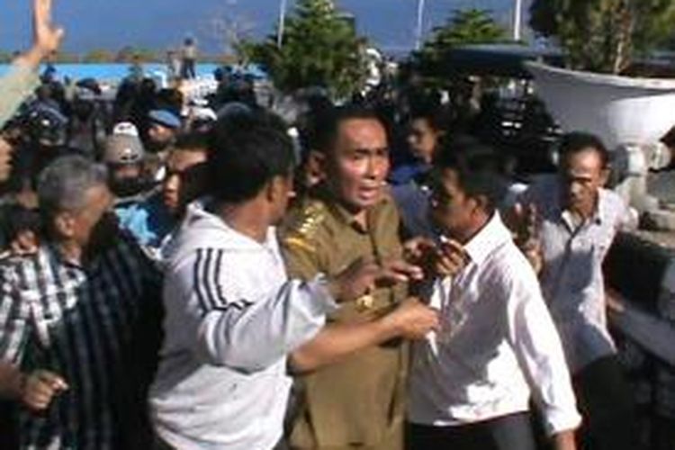 Bupati Buton, Umar Samiun dievakuasi setelah terkena pukulan di kepalanya saat melindungi seorang demonstran yang dipukul polisi saat terjadi bentrokan di depan rumah jabatan bupati Buton.  