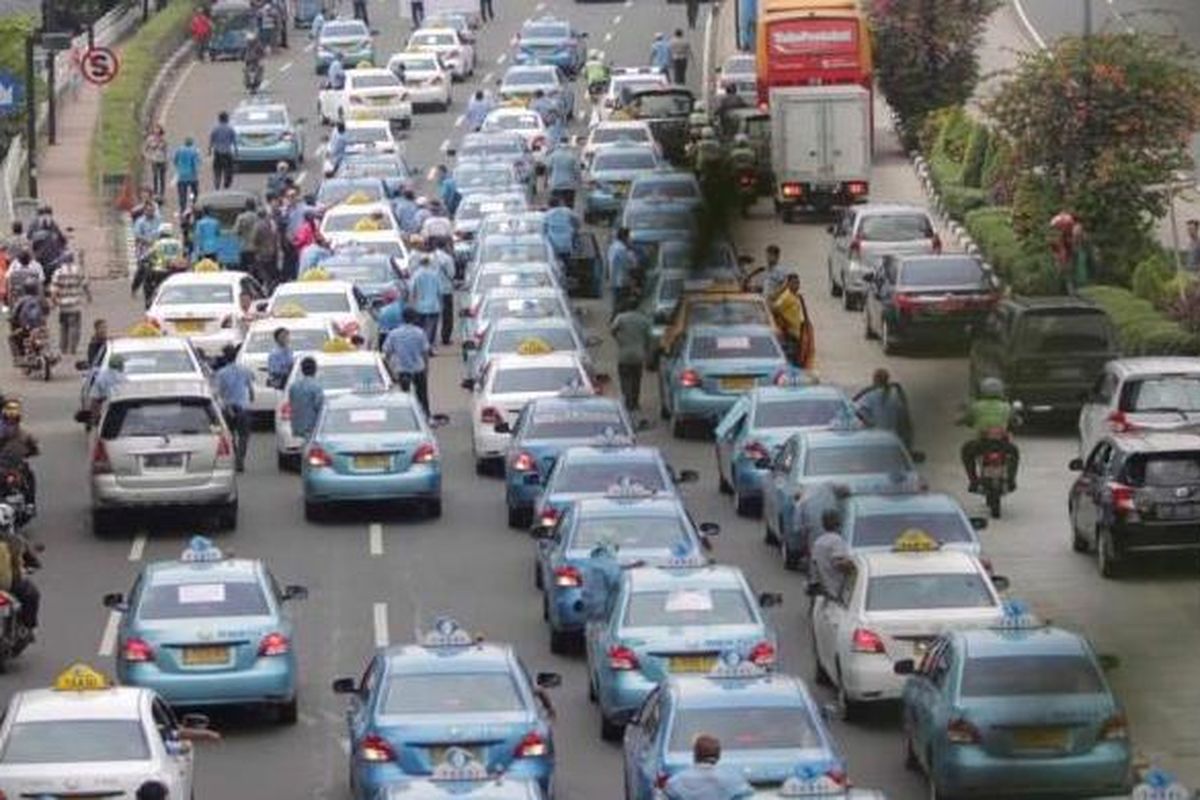 Gabungan sopir taksi dan bajaj melakukan aksi demonstrasi di sepanjang Jalan Sudirman, Jakarta, Selasa (22/3/2016). Mereka menuntut pemerintah menutup angkutan umum berbasis online karena dianggap mematikan mata pencaharian mereka.