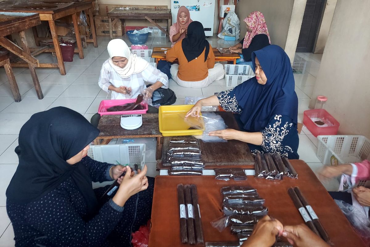 Setelah proses pemasakan selesai, karyawan wanita sedang mengemas dodol