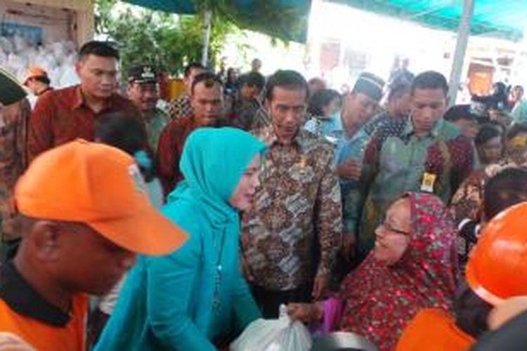 Presiden Joko Widodo membagikan paket sembako untuk masyarakat di RW 08, Kelurahan Kedoya Utara, Kecamatan Kebon Jeruk, Jakarta Barat.