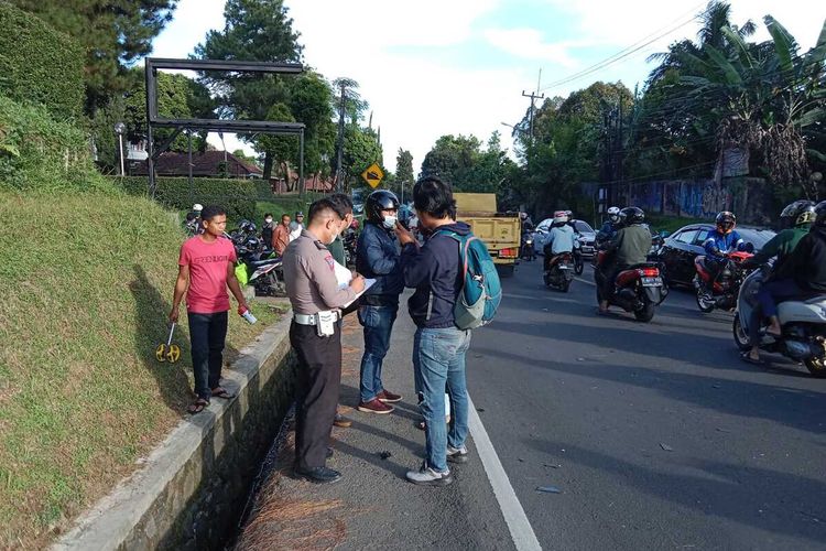 Petugas kepolisian sedang mengevakuasi kendaraan yang terlibat kecelakaan beruntun di Jalur Puncak Bogor, Jawa Barat, Minggu (20/3/2022).