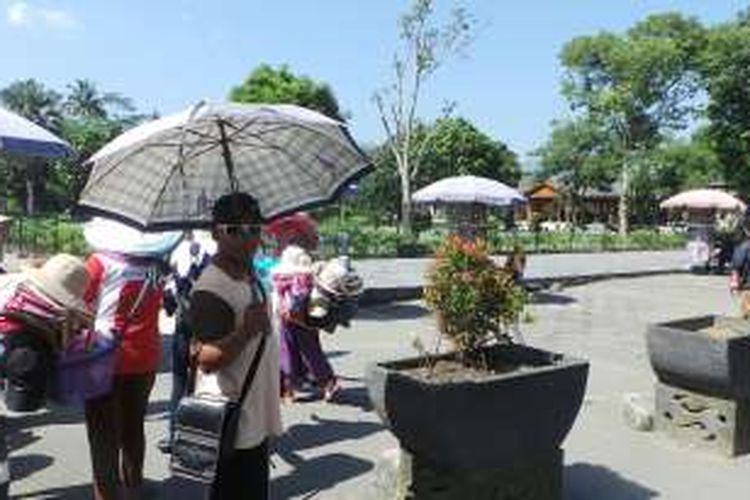 Seorang pemberi jasa penyewaan payung di Candi Borobudur, Magelang, Jawa Tengah, Rabu (24/2/2016). Harga sewa payung dipatok harga Rp 10.000.