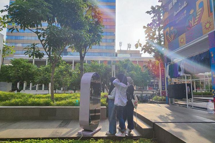 Mencoba mesin foto gratis di depan Gedung Sarinah, Jumat (28/4/2023)