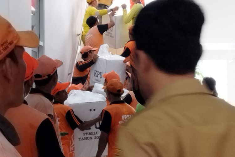 Pasukan oranye berjibaku menurunkan kotak suara dari lantai empat ke lobi di kantor Kecamatan Johar Baru, Jakarta Pusat, Selasa (13/2/2024).