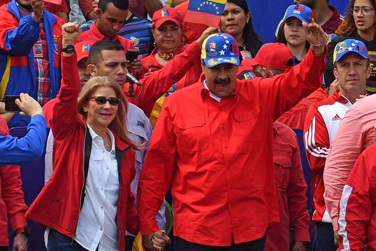Presiden Venezuela Nicolas Maduro (tengah) didampingi istrinya, Cilia Flores, tampil di hadapan massa pro-rezim saat aksi memperingati 20 tahun revolusi di Caracas, Sabtu (2/2/2019).