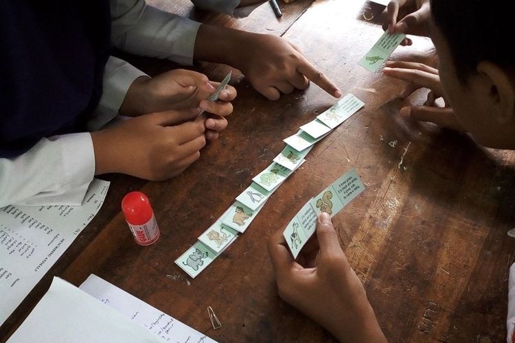 Siswa Kelas VIIE SMPN 5 Purwokerto, Jawa Tengah, tampak asyik memainkan Domino belajar teks deskriptif dalam bahasa Inggris.