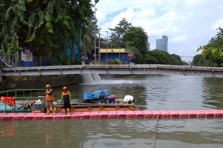 Petugas penyaring sampah di pintu air 8 Kali Sunter, Senin (24/2/2020).