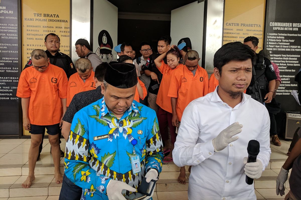 Polisi saat memberi keterangan pers tentang kasus penipuan bermodus undian berhadiah yang dilakukan UD Surya Agung Perdana. Yang berbaju oranye di latar belakang merupakan para tersangka dalam kasus itu.