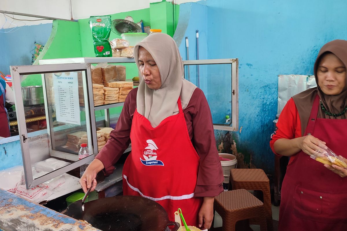 Ninik sri, (48) pedagang roti bakar di kantin SMP 10 Jakarta, Kramatjati, Jakarta Timur saat membuat roti untuk siswa yang membuat. Jumat (21/11/2024).