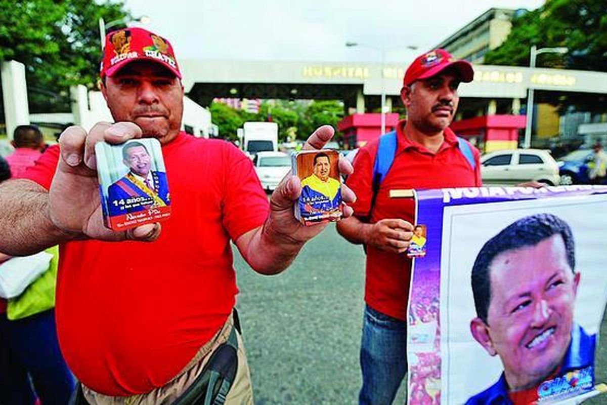 Pendukung Presiden Venezuela Hugo Chavez dan penjual suvenir menunggu di luar Rumah Sakit Militer Carlos Avero di Caracas, tempat Chavez menjalani perawatan setelah tiba kembali di Venezuela, Senin (18/2). Chavez tiba di Caracas, Senin   dini hari, setelah menjalani operasi kanker dan dirawat selama lebih dari dua bulan di Havana, Kuba. Kepulangannya yang tidak diduga diumumkan sendiri oleh Chavez lewat akun Twitter-nya. Menteri Ilmu Pengetahuan dan Teknologi Jorge Arreaza, yang juga menantu Chavez, mengatakan, presiden berusia 58 tahun itu akan melanjutkan perawatan medis di rumah sakit militer tersebut.