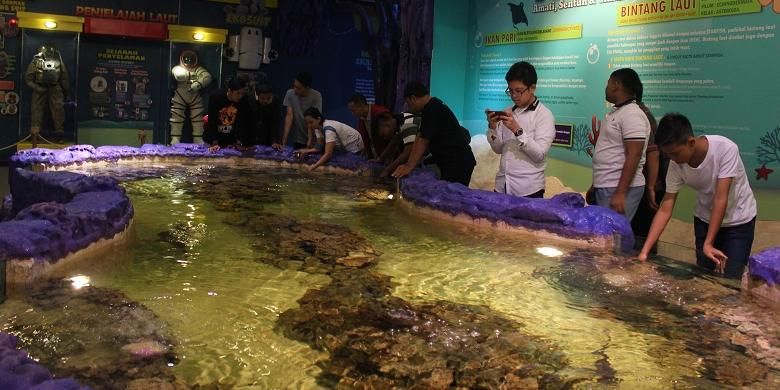 Para pengunjung mencoba menyentuh aneka hayati laut dari anak ikan hiu hingga bintang laut di area Touch Pond, Trans Studio Bandung, Sabtu (19/12/2015).