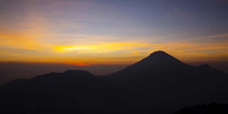 Matahari terbit di belakang Gunung Sundoro terlihat dari Bukit Sikunir, Dataran Tinggi Dieng, Wonosobo, Jawa Tengah, Sabtu (1/11/2014). Dieng menawarkan keindahan sekaligus ancaman, karena dataran tingginya terbentuk dari gunung berapi yang kini masih mengeluarkan gas.