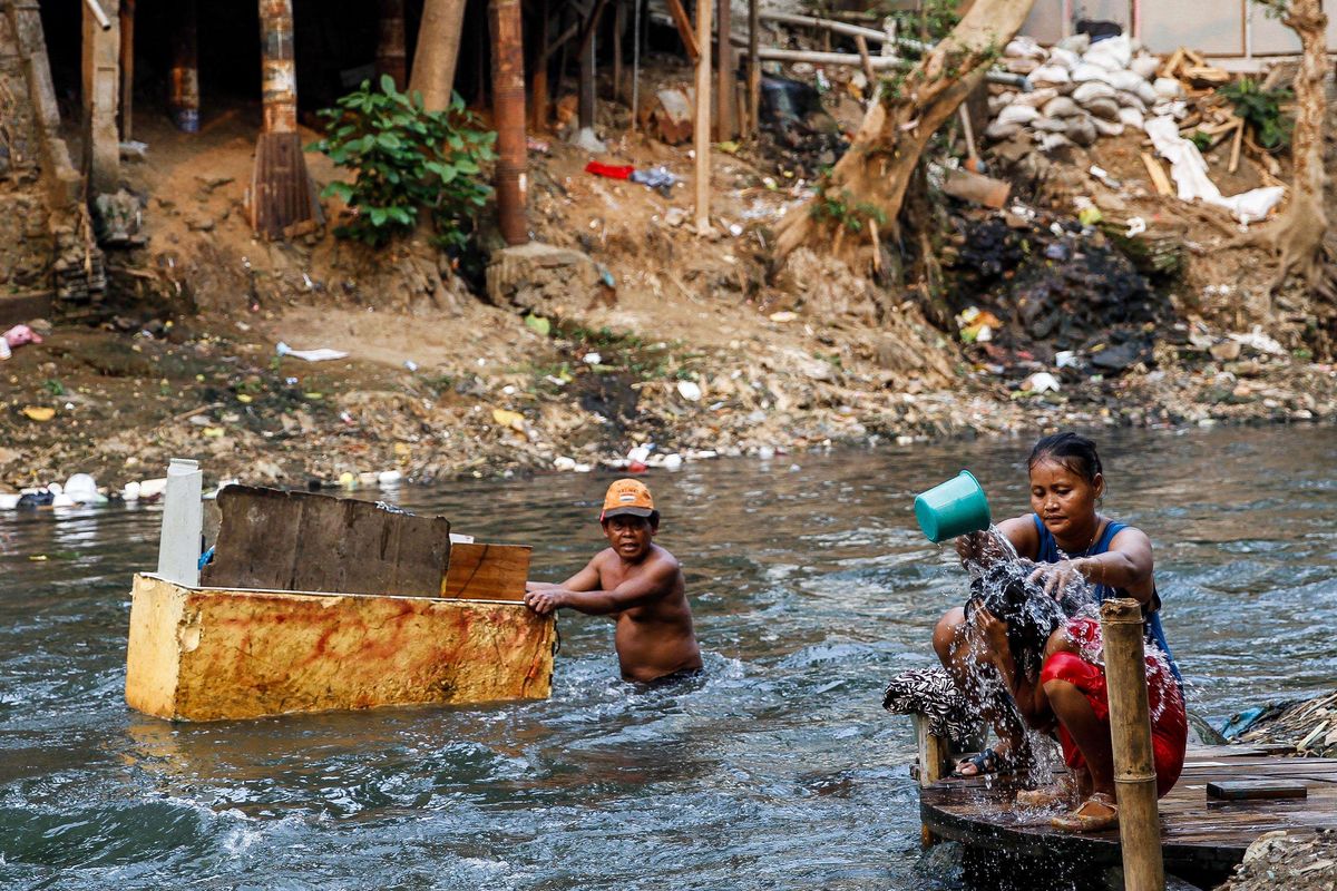 Warga beraktivitas di pemukiman padat penduduk di bantaran Sungai Ciliwung, Manggarai, Jakarta, Minggu (28/7/2019). 