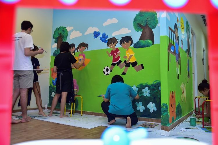 Siswa JIS dari kelas creative arts menggambar mural di ruang keluarga RMHC di Rumah Sakit Ciptomangunkusumo