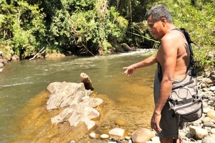 Mawi menunjuk batu di mana harimau membunuh manusia.