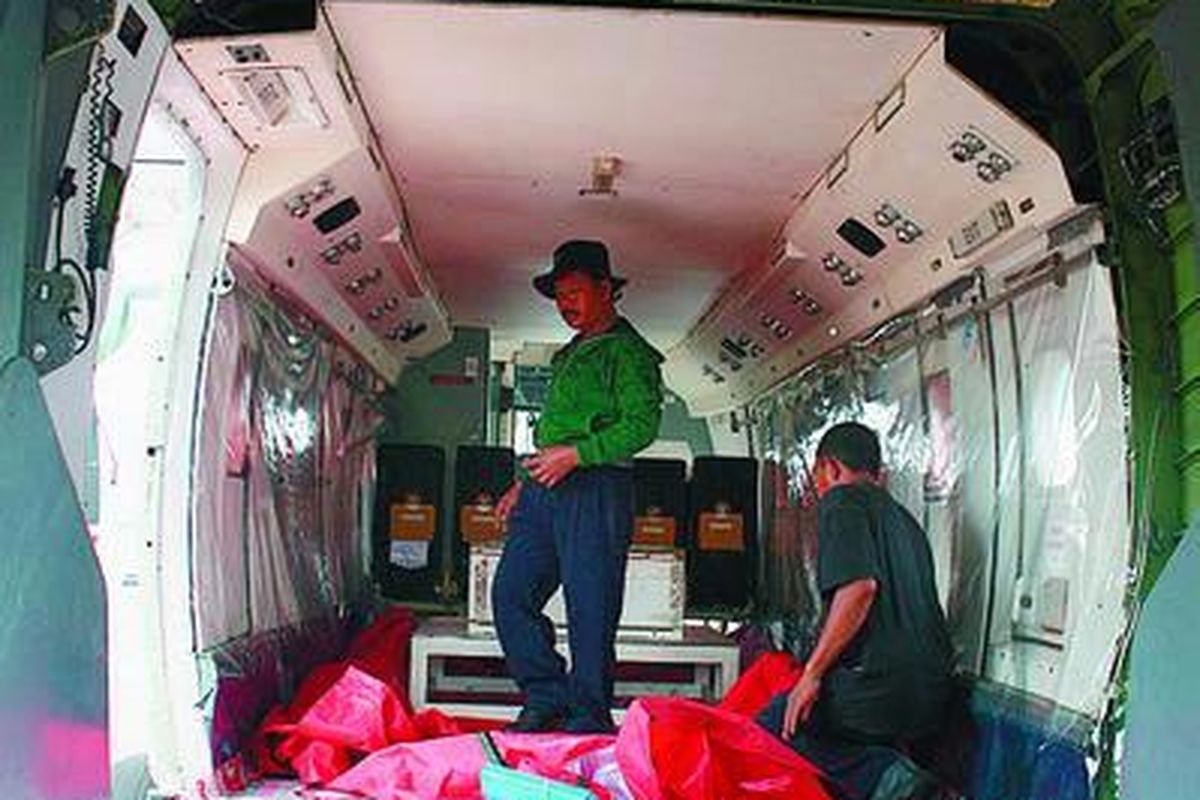 Awak pesawat menyiapkan peralatan untuk membuat hujan buatan di dalam pesawat Cassa 212 di Bandara Sultan Mahmud Badaruddin II, Palembang, Sumsel, Sabtu (3/10). Pesawat tersebut akan mulai membuat hujan buatan pada hari Minggu untuk menghilangkan kabut asap akibat kebakaran lahan di Sumsel.