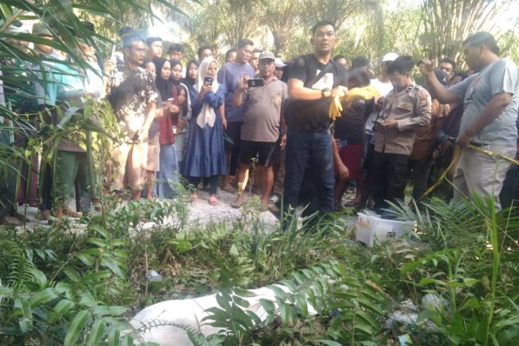 Anggota Polsek Tapung melakukan olah TKP kasus temuan mayat wanita di pinggir jalan di Desa Kinantan, Kecamatan Tapung, Kabupaten Kampar, Riau, Minggu (21/4/2024).