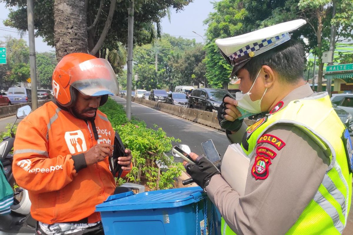 Seorang kurir bernama Amsi (25) yang terkena tilang manual di Jalan Warung Jati Barat, Jakarta Selatan, Rabu (17/5/2023). 