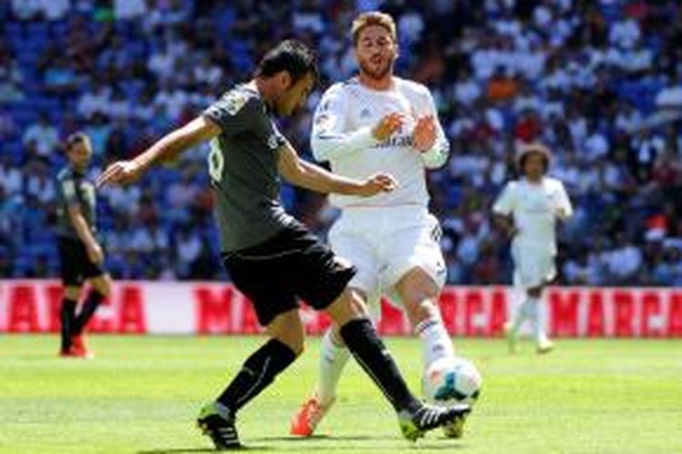 Bek Real Madrid, Sergio Ramos, berusaha menghentikan salah satu pemain Espanyol, pada laga Primera Division di Santiago Bernabeu, Sabtu (17/5/2014). 