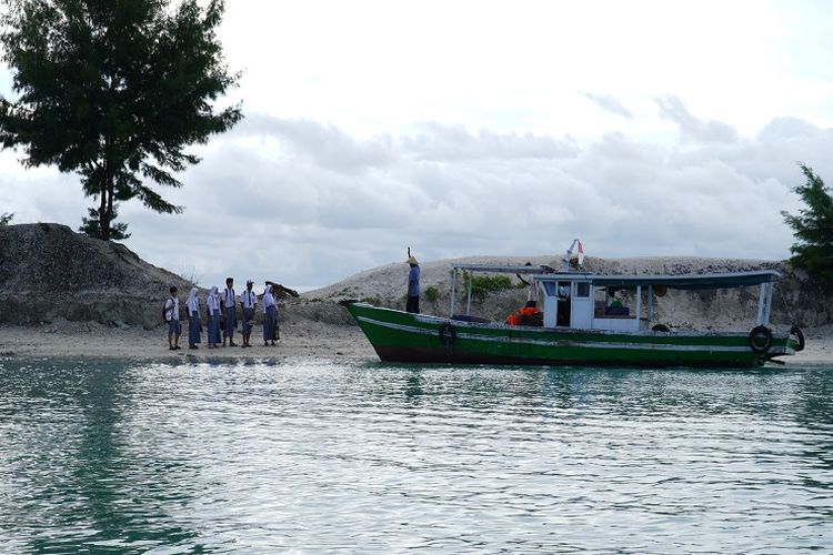 Seorang nelayan sedang menjemput pelajar SMAN 69 di Pulau Pramuka.