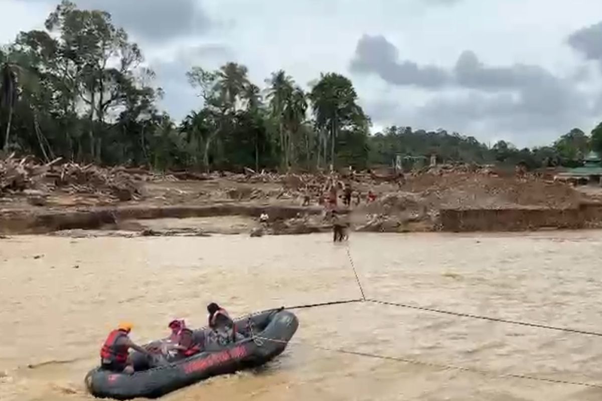 Polisi saat menyebrangkan warga yang sakit dengan perahu karet di Desa Garoga, Batang Toru,Tapanuli Selatan (Tapsel) Sumatera Utara, Selasa (10/12/2025).