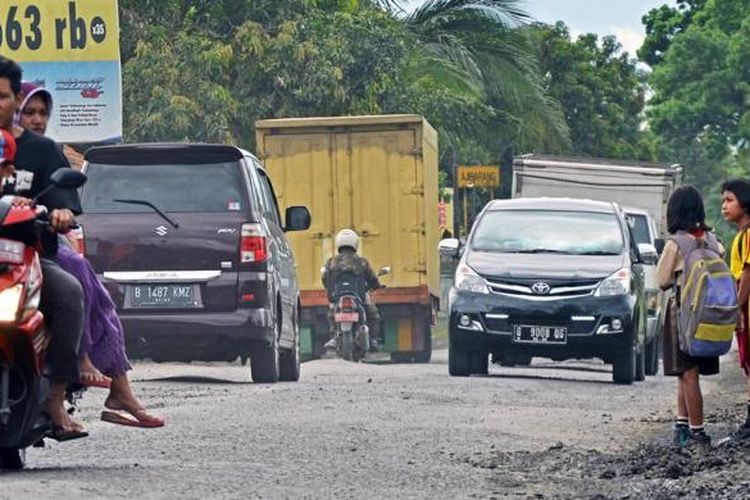 Pengendara motor melintasi jalan berlubang dan bergelombang di Jalan Raya Brebes-Ajibarang, di Kecamatan Pekuncen, Kabupaten Banyumas, Jawa Tengah, Senin (16/1/2017). Jalur nasional tersebut dinilai sudah tidak memadai. Lebar jalur rata-rata hanya enam meter sehingga tidak berimbang dengan intensitas kendaraan berat yang semakin banyak melintasi jalur tersebut. Kondisi jalan yang cepat rusak juga menyebabkan ruas penghubung jalur pantura dengan jalur selatan Jateng ini rawan kecelakaan.