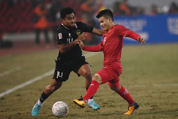 Pesepak bola Timnas Indonesia Asnawi Mangkualam (kiri) berebut bola dengan pesepak bola Timnas Vietnam Nguyen Quang Hai dalam pertandingan leg 2 babak semi final Piala AFF 2022 di Stadion Nasional My Dinh, Hanoi, Vietnam, Senin (9/1/2023). Timnas Indonesia tak berhasil ke final setelah kalah dari Vietnam pada leg kedua semifinal Piala AFF 2022. 