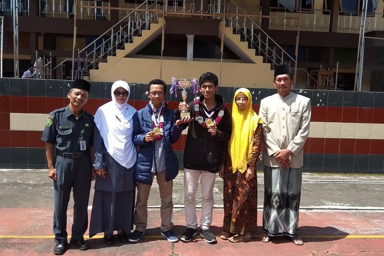 Muhammad Usman Muqoffa (18) dan Muhammad Farkhan Suha (18) (memegang piala) disambut oleh guru dan orangtua di SMAN 1 Grabag Kabupaten Magelang setelah menyabet emas di ajang Hongkong Student Science Project Competition (HKSSPC) di Hongkong, 21-24 Maret 2018.