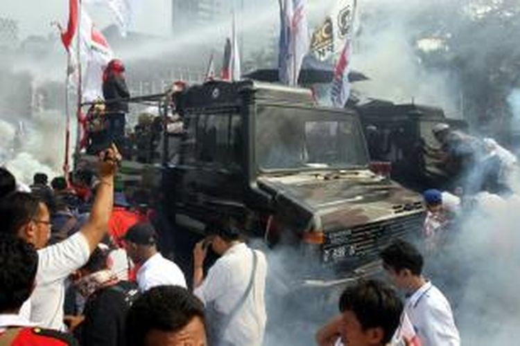 Polisi menembakkan gas air mata dan meriam air ke arah massa pendukung Prabowo-Hatta yang mendesak mendekati Gedung Mahkamah Konstitusi (MK), Jakarta Pusat, Kamis (21/8/2014). Massa memaksa mendekati Gedung MK melalui Jalan Medan Merdeka Barat yang disterilkan polisi karena adanya sidang putusan gugatan Pilpres 2014.