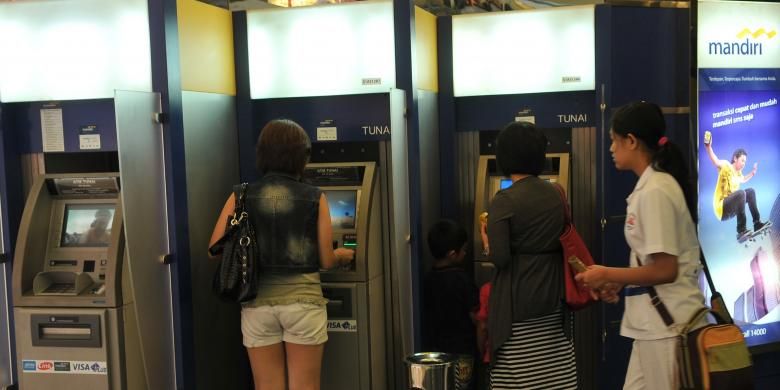 Pengambilan uang tunai di Anjungan Tunai Mandiri (ATM) Bank Mandiri, Jakarta