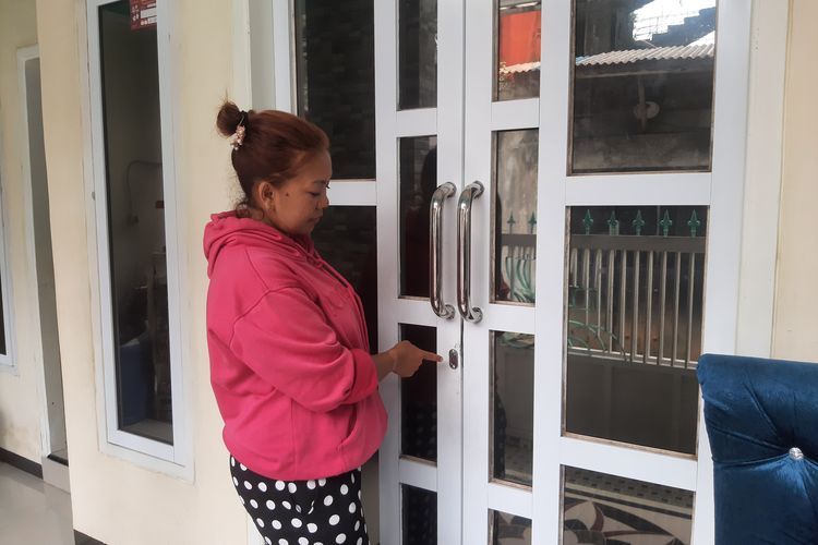 Wahyuni tunjukkan pintu rumahnya yang rusak karena dicongkel kawanan perampok, Sabtu (17/2/2024).