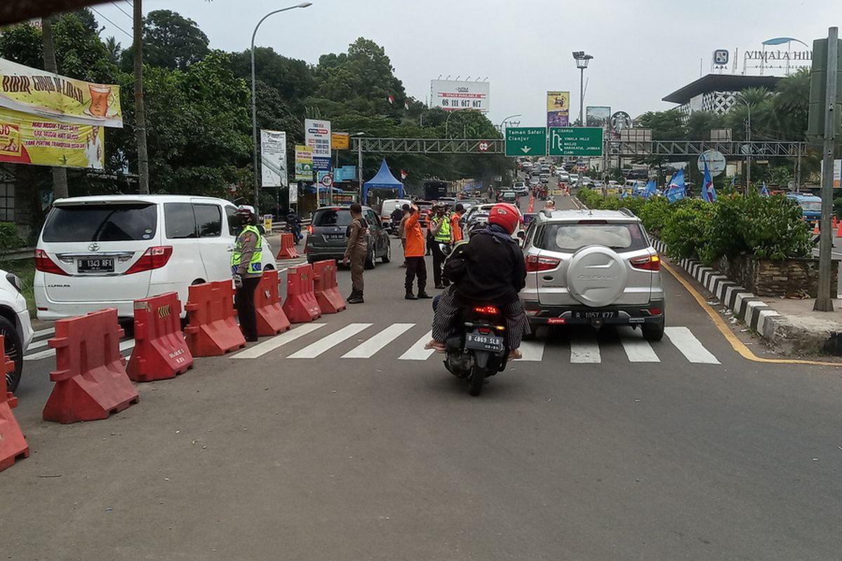 Sejumlah petugas gabungan mengkombinasikan rekayasa lalu lintas berupa ganjil genap dan sistem satu arah atau one way di Jalur Puncak Bogor, Jawa Barat, Minggu (19/9/2021).