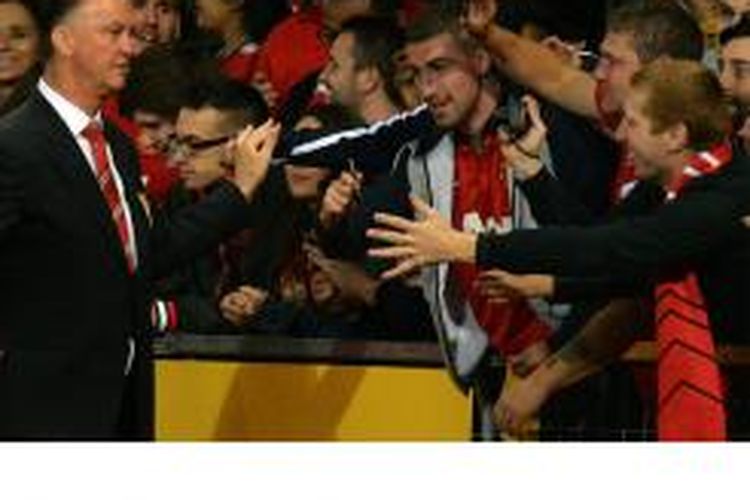 Manajer Manchester United Louis Van Gaal memberikan tanda tangan kepada para penonton setelah laga pra-musim antara MU dan Valencia di Old Trafford, Manchester, Selasa (12/8/2014).