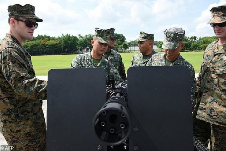 Marinir Filipina dan mitra Amerika Serikat (AS)-nya mengamati sebuah senapan mesin M134D yang baru saja diserahkan kepada Filipina di Manila, Senin (5/6/2017).