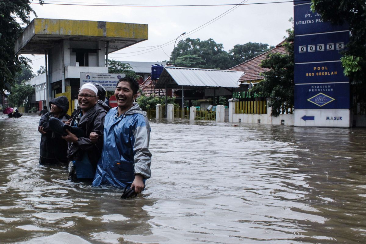 Suasana di depan Pool Bus Sekolah Jalan Raya Pondok Gede, Kramat Jati, Jakarta Timur, Selasa (25/2/2020) yang terendam banjir. Banjir di kawasan tersebut sudah terjadi pukul 04.00 WIB.