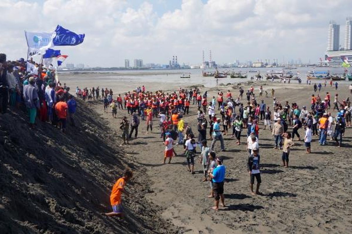 Warga menjejakkan kaki pertama kali di Pulau G, saat melakukan aksi penyegelan pulau, Minggu (17/4/2016). Aksi yang diikuti ratusan warga pesisir Jakarta ini merupakan bentuk penolakan reklamasi Teluk Jakarta yang tengah berlangsung.