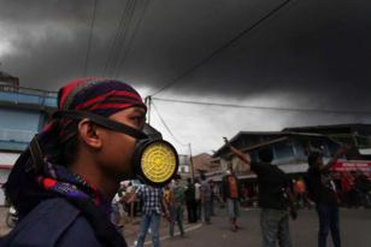 Warga berhamburan keluar rumah ketika abu vulkanik letusan Gunung Sinabung menutupi langit di Kabupaten Karo, Sumut, Selasa, 17 September 2013. Gunung kembali meletus pada pukul 12.03. Status gunung Siaga III.