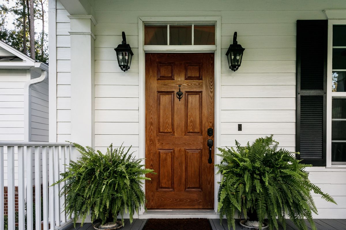 Ilustrasi pintu depan rumah dari material kayu.